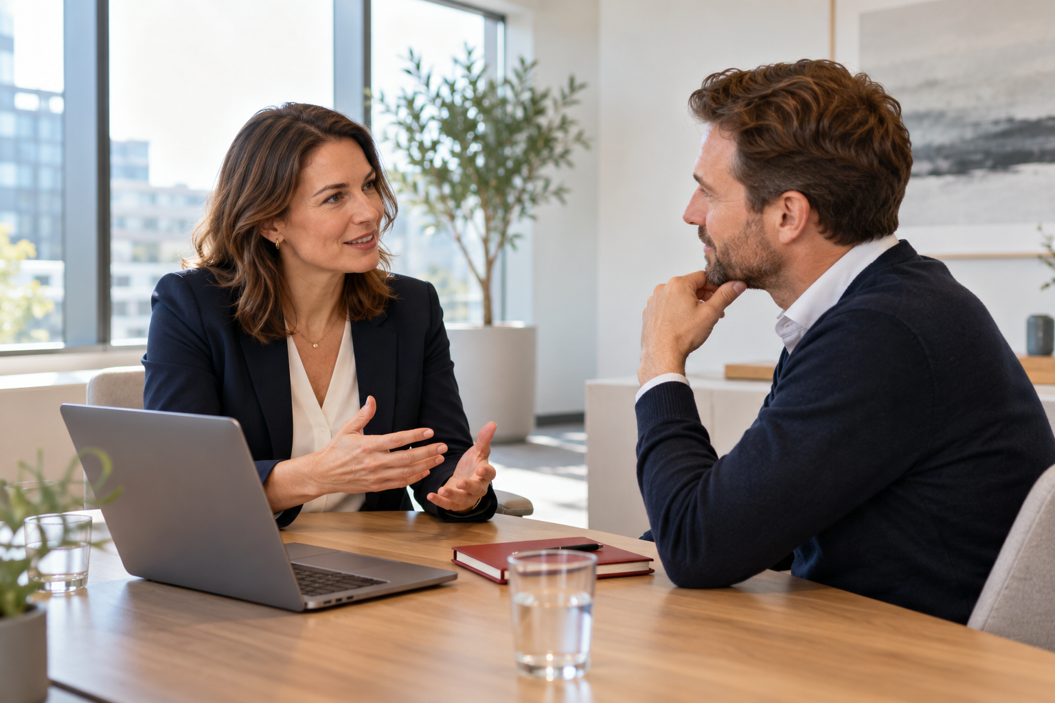 Two professionals discussing technology needs at a meeting table.