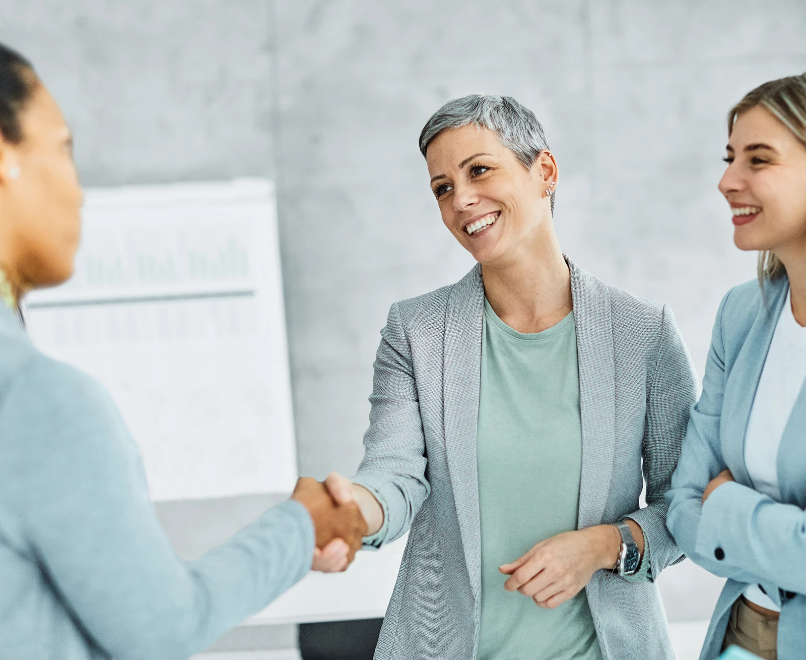 Two people shaking hands during an office meeting.